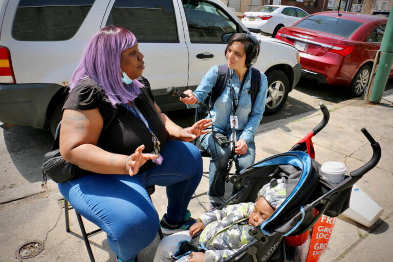 WHYY's Sammy Caiola talks with Tamika Borum at Tynirah's Community Welcome Garden in Gray's Ferry. The garden was named in honor of Borum's daughter, who was shot to death in 2014 at the age of 3 outside her home.  (Emma Lee/WHYY)