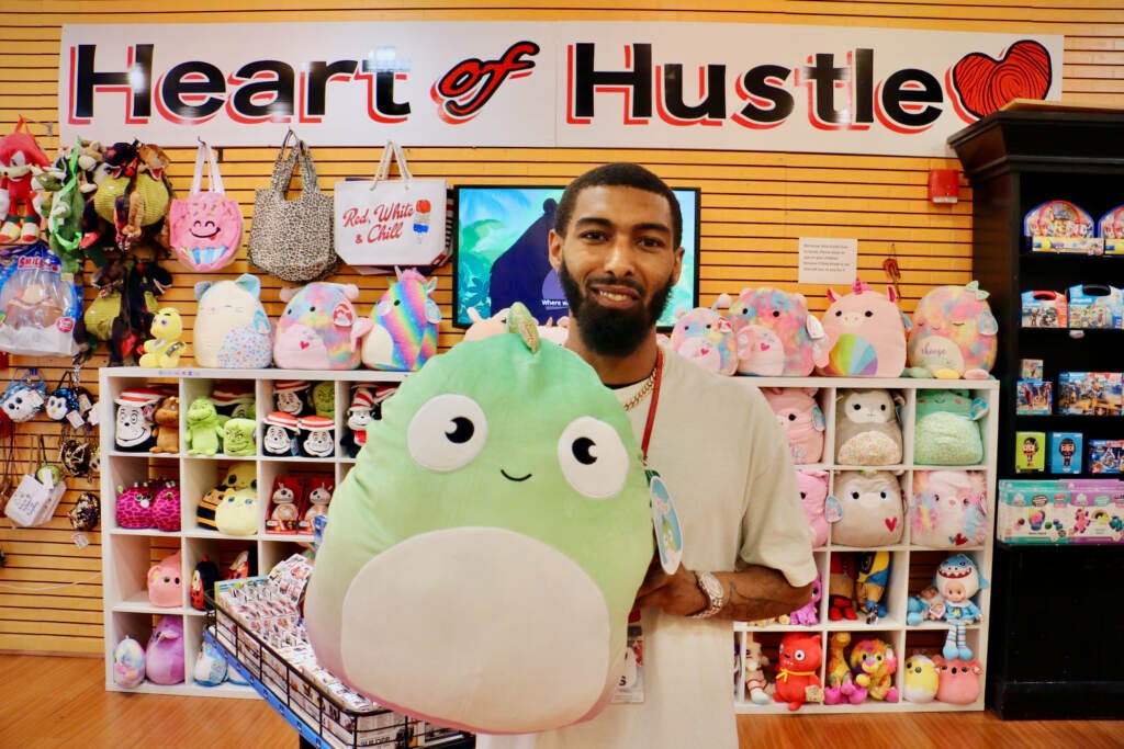 Chris Newsome holds a stuffed animal inside Heart of Hustle at the Cumberland Mall