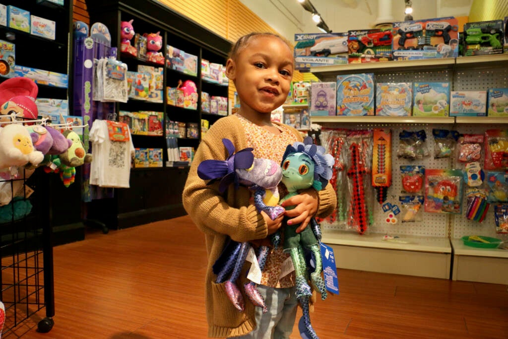 Sa'Niya Newsome holds two plush Disney toys inside the Heart of Hustle store