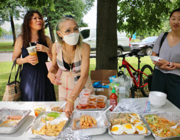 Saijai Sabayjit (center) of Saijai Thai sets out samples of her fried tofu. She is one of three vendors from the Southeast Asian Market at FDR Park chosen to serve food at the Philadelphia Flower Show. (Emma Lee/WHYY)