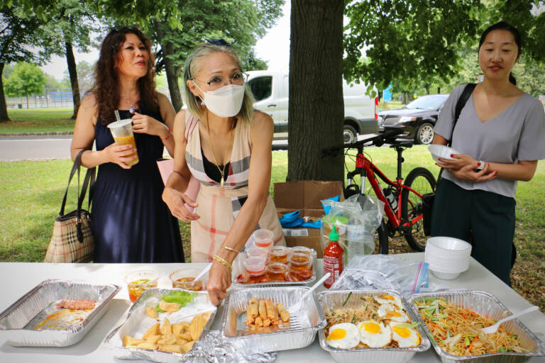 Saijai Sabayjit (center) of Saijai Thai sets out samples of her fried tofu. She is one of three vendors from the Southeast Asian Market at FDR Park chosen to serve food at the Philadelphia Flower Show. (Emma Lee/WHYY)