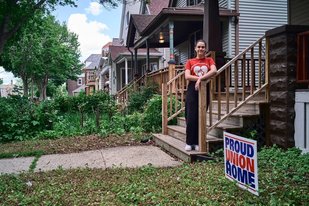 Kellie Lutz stands on the stoop outside her home, with a ''Proud Union Home'' sign visible on the lawn