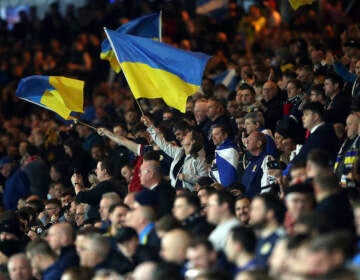 Football supporters show their support to Ukraine during the International Friendly soccer match between Scotland and Poland at Hampden Park stadium in Glasgow, Scotland, Thursday, March. 24, 2022. (AP Photo/Scott Heppell)