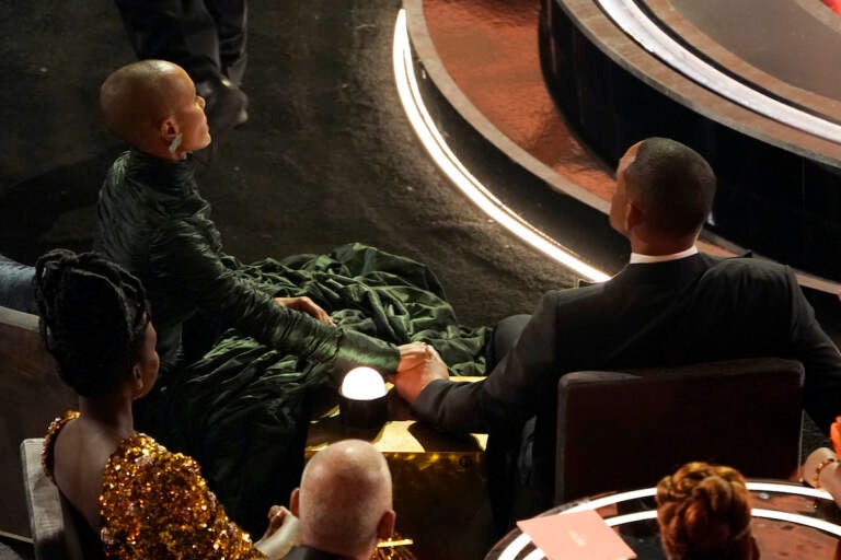File photo: Jada Pinkett Smith, left, and Will Smith hold hands in the audience at the Oscars in Los Angeles on March 27, 2022. Will Smith stunned the audience of the 94th Academy Awards ceremony on Sunday when he walked onstage and slapped comedian Chris Rock over a joke the presenter made about his wife. Pinkett Smith turned her husband’s Oscar-night blowup into a teachable moment on “Red Table Talk,” her Facebook Watch show on June 1. (AP Photo/Chris Pizzello, File)