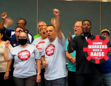 Members of Local 54, a union of Atlantic City casino workers, stand together, with one person raising their fist in celebration.