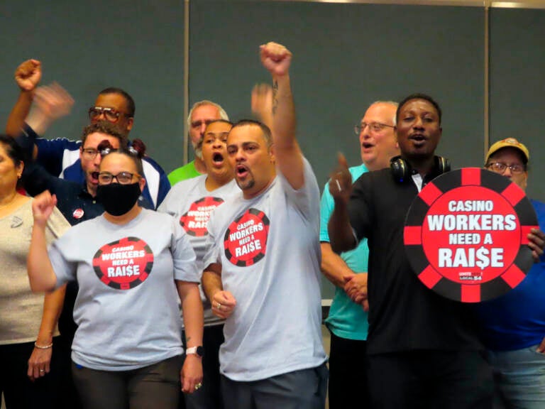 Members of Local 54, a union of Atlantic City casino workers, stand together, with one person raising their fist in celebration.