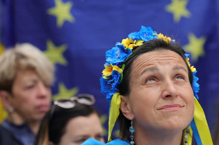 A protestor wears a flower headband in the Ukraine colors as she participates in a demonstration in support of Ukraine outside of an EU summit in Brussels, Thursday, June 23, 2022. (AP Photo/Olivier Matthys)