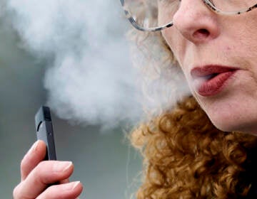File photo: A woman exhales while vaping from a Juul pen e-cigarette in Vancouver, Wash., April 16, 2019. (AP Photo/Craig Mitchelldyer, File)