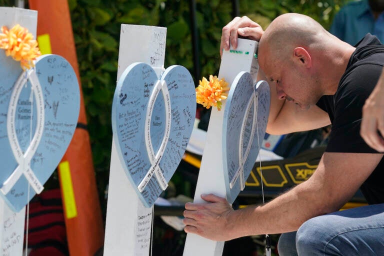 Lazaro Carnero mourns for his best friend Edgar Gonzalez, during a remembrance event at the site of the Champlain Towers South building collapse, Friday, June 24, 2022, in Surfside, Fla. (AP Photo/Wilfredo Lee)