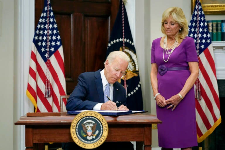 President Joe Biden signs into law S. 2938, the Bipartisan Safer Communities Act gun safety bill, in the Roosevelt Room of the White House in Washington, Saturday, June 25, 2022. First lady Jill Biden looks on at right. (AP Photo/Pablo Martinez Monsivais)