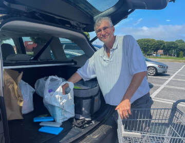 Bob Hayman has accumulated lots of thick reusable plastic bags that stores provided after they exploited a legal loophole. (Cris Barrish/WHYY)