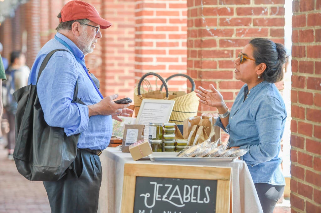 Jezabel Careaga, right, speaks with a customer at her stall at the Headhouse Farmers Market.