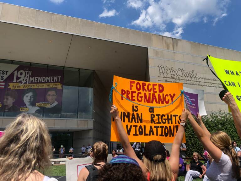 Rally-goers hold up signs at the rally in defense of abortion rights at Philadelphia’s National Constitution Center on June 25, 2022. (Emily Rizzo/WHYY)