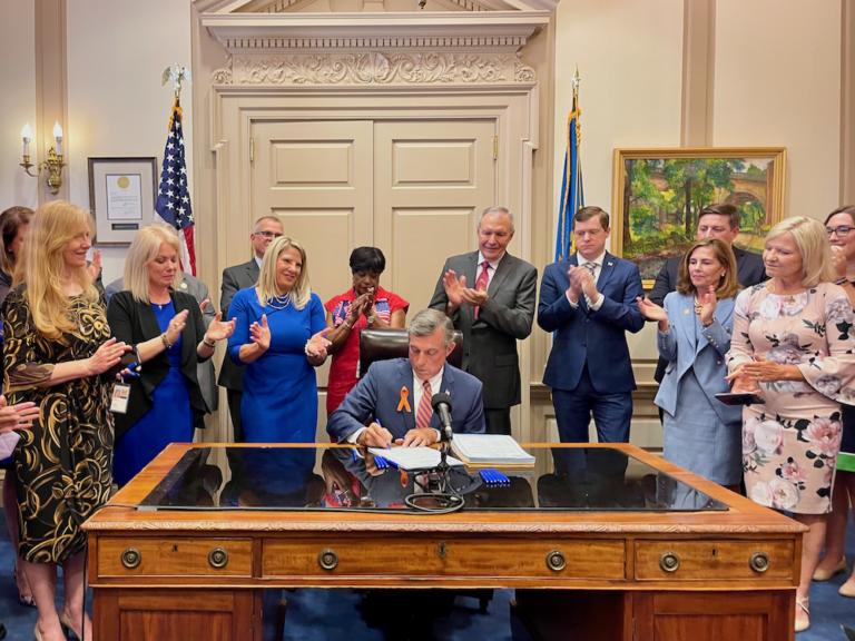 Delaware Gov. John Carney signs a package of gun safety bills. (Johnny Perez-Gonzalez/WHYY)