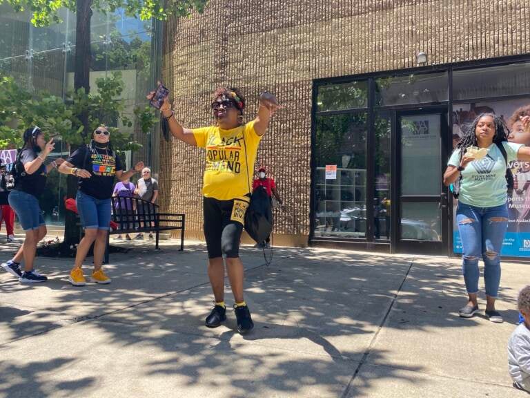 A person dances in the center of a group of people who also are dancing.