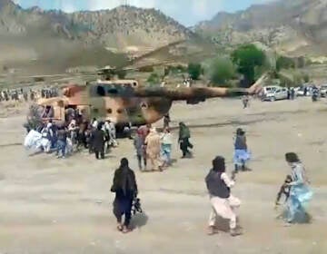 Taliban fighters secure a government helicopter to evacuate injured people in Gayan district