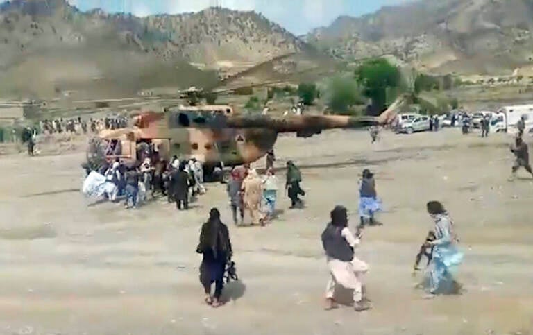 Taliban fighters secure a government helicopter to evacuate injured people in Gayan district