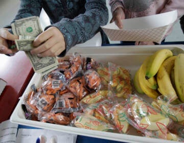 A student pays for lunch of fruits and vegetables during a school lunch program. (Paul Sakuma/AP)