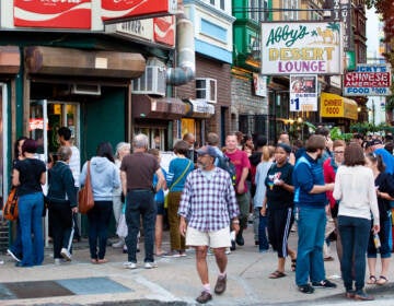 People are seen on Baltimore Avenue during the Dollar Stroll