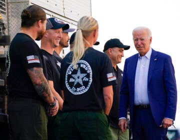 President Biden stands with a group of federal firefighters.