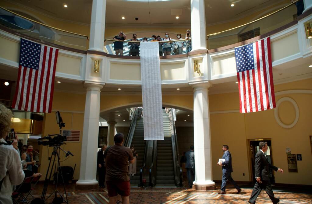 Climate activists unfurl a petition that was delivered to Gov. Tom Wolf before a Pennsylvania Climate Convergence press conference in the East Wing of the Capitol complex