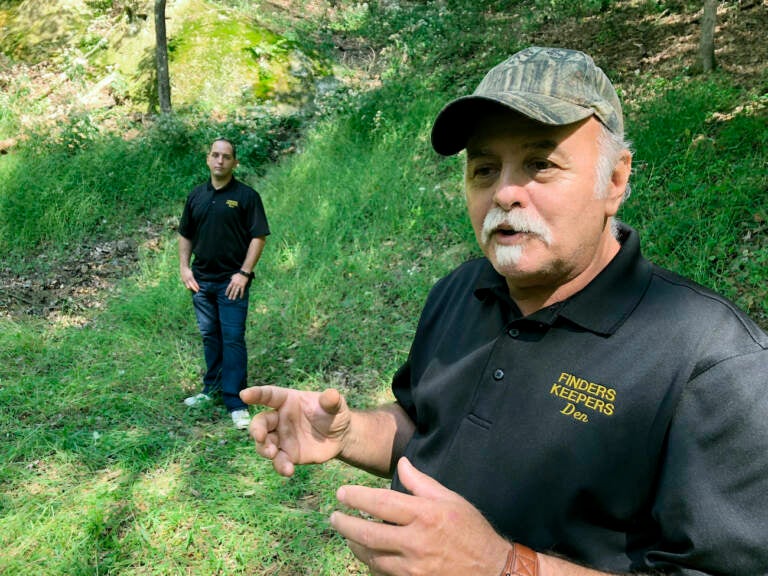 FILE - Dennis Parada, right, and his son Kem Parada stand at the site of the FBI's dig for Civil War-era gold in Sept, 2018, in Dents Run, Pennsylvania. A scientific report commissioned by the FBI shortly before agents went digging for buried treasure suggested that a huge quantity of gold was below the surface, according to newly released government documents. (AP Photo/Michael Rubinkam, File)