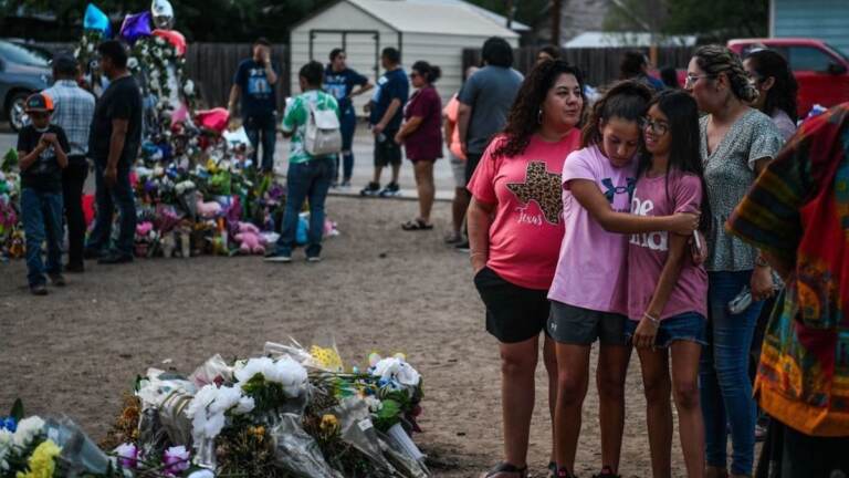 People mourn at a makeshift memorial for the victims of the Robb Elementary School shooting