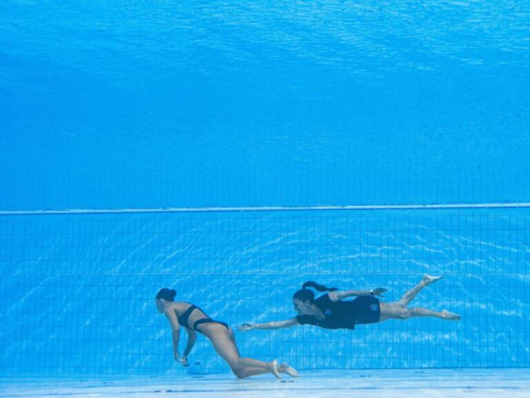 Team USA coach Andrea Fuentes swims toward Anita Alvarez, who sank to the bottom of the pool Wednesday during the women's solo free artistic swimming finals at the Budapest 2022 World Aquatics Championships.
(Oli Scarff/AFP via Getty Images)