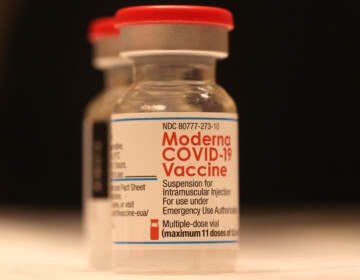 A vial of Moderna's COVID-19 vaccine sits on a table