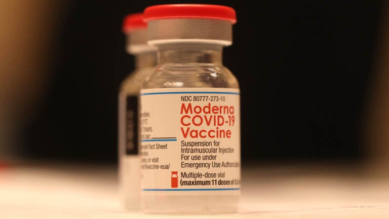 A vial of Moderna's COVID-19 vaccine sits on a table