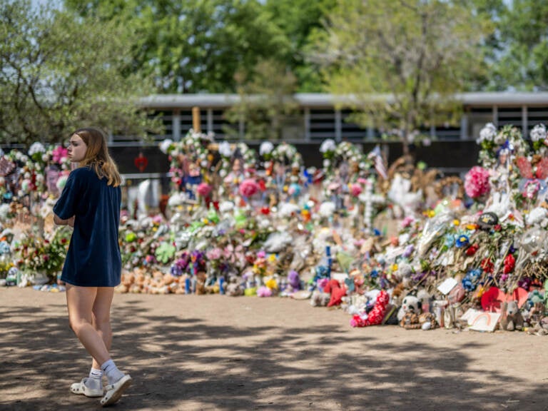 A young woman pays her respects at a memorial in front of Robb Elementary School earlier this monthin Uvalde, Texas. Committees have begun inviting testimony from law enforcement authorities, family members and witnesses regarding the mass shooting at Robb Elementary School which killed 19 children and two adults. (Brandon Bell/Getty Images)