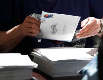 A close-up of someone handling a mail-in ballot.