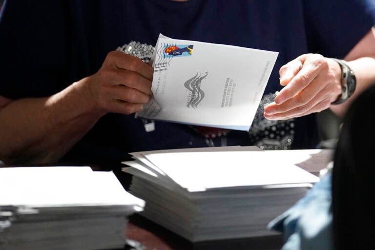 A close-up of someone handling a mail-in ballot.