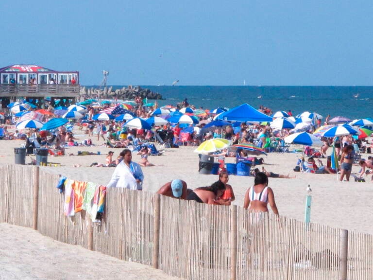 Beachgoers are seen on the beach at the Jersey Shore, with the ocean in the background.