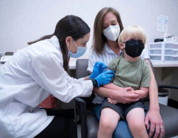 Pharmacist Kaitlin Harring, left, administers a Moderna COVID-19 vaccination to 3-year-old Fletcher Pack