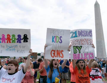 People hold signs in the second March for Our Lives rally in support of gun control