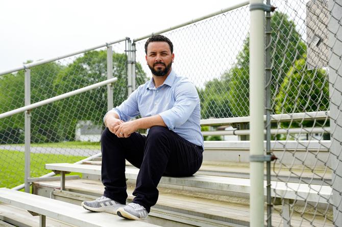 Omy Maldonado sits on bleachers outside