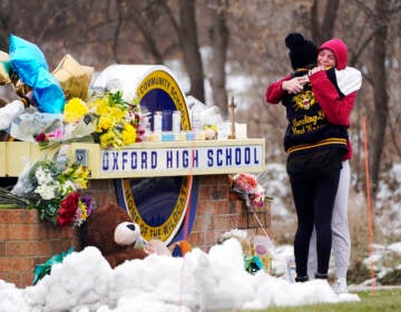 Students hug at a memorial at Oxford High School in Oxford, Mich., Dec. 1, 2021.