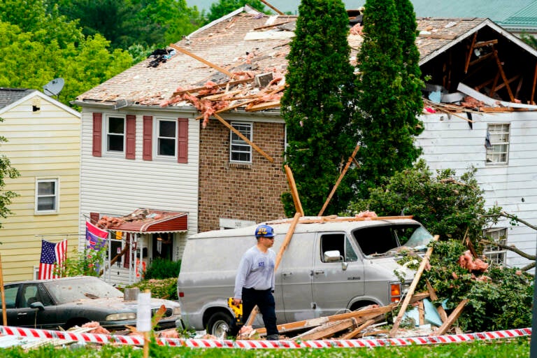 An investigator moves through the scene of a deadly explosion in a residential neighborhood in Pottstown