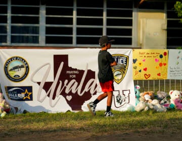 A boy walks in front of a memorial to the victims of the mass shooting in Uvalde, Texas.