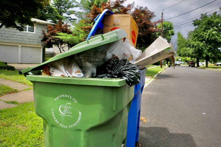 Garbage and recycling containers overflow on a residential street in Cherry Hill Township, New Jersey. (Emma Lee/WHYY)