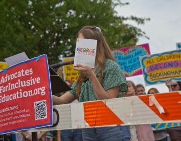 Lilly Freeman holds up a that helped her transition at a rally ahead of the Central Bucks School District’s vote to remove books perceived to have sexualized content from their libraries