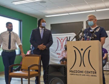 During a press conference Friday at the Mazzoni Center, Pa. State Representatives Brian Sims (left), and Malcolm Kenyatta (center), joined Mazzoni Center medical assistant Steven Roberston, who said the clinic's staff has not received enough vaccines to meet their patients' needs. (Kimberly Paynter/WHYY)