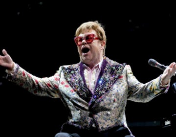 Elton John gestures during a performance