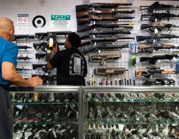 Sales associate Elsworth Andrews grabs a shot gun to show it to a customer at Burbank Ammo & Guns in Burbank, Calif., Thursday, June 23, 2022. The Supreme Court has ruled that Americans have a right to carry firearms in public for self-defense, a major expansion of gun rights. The court struck down a New York gun law in a ruling expected to directly impact half a dozen other populous states. (AP Photo/Jae C. Hong)