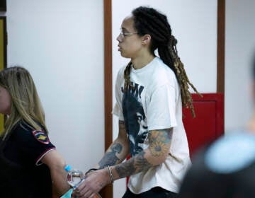 WNBA star and two-time Olympic gold medalist Brittney Griner is escorted to a courtroom for a hearing, in Khimki just outside Moscow, Russia, Friday, July 1, 2022. (AP Photo/Alexander Zemlianichenko)