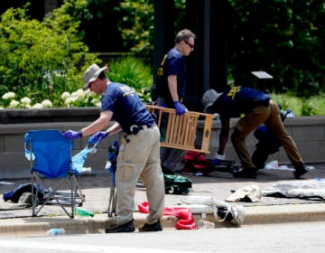 Members of the FBI's evidence response team remove personal belongings one day after a mass shooting in downtown Highland Park, Ill., Tuesday, July 5, 2022. (AP Photo/Charles Rex Arbogast)