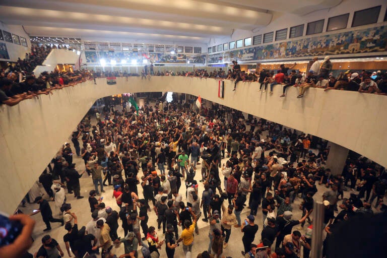 Iraqi protesters fill the Parliament building in Baghdad, Iraq, Saturday, July 30, 2022 as thousands of followers of an influential Shiite cleric breached the building for the second time in a week to protest the government formation efforts lead by Iran-backed groups. (AP Photo/Anmar Khalil)