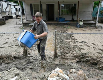 Members of the local Mennonite community remove mud filled debris from homes following flooding at Ogden Hollar in Hindman, Ky., Saturday, July 30, 2022. (AP Photo/Timothy D. Easley)