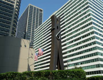 The Clothespin is visible, with buildings and the American flag in the background.